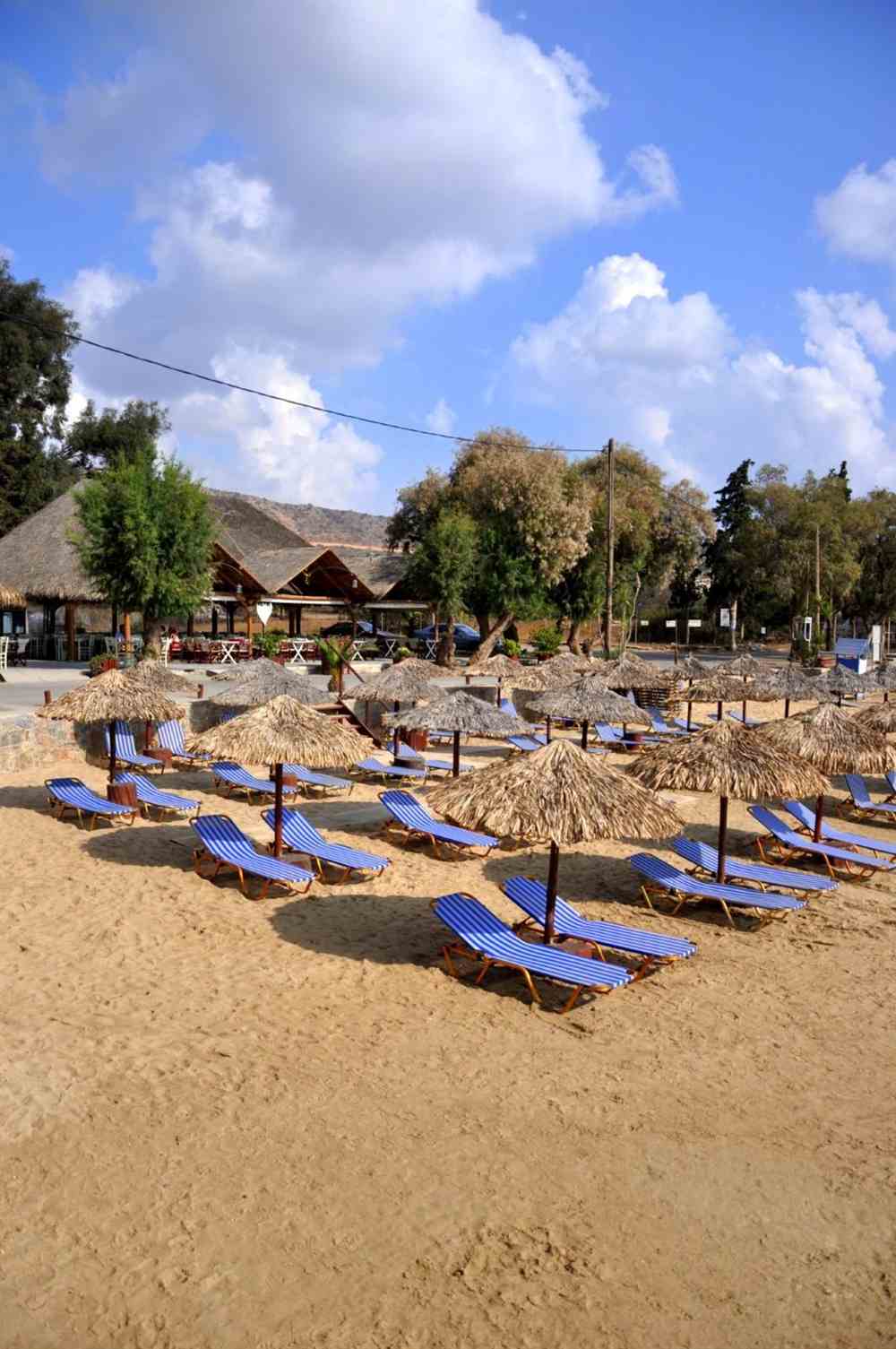 Sunbeds and straw umbrellas on the sand at Marathi beach, Akrotiri, Crete