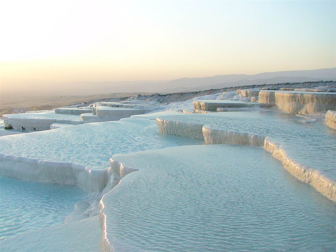The white travertine terraces of Pamukkale glowing at sunset
