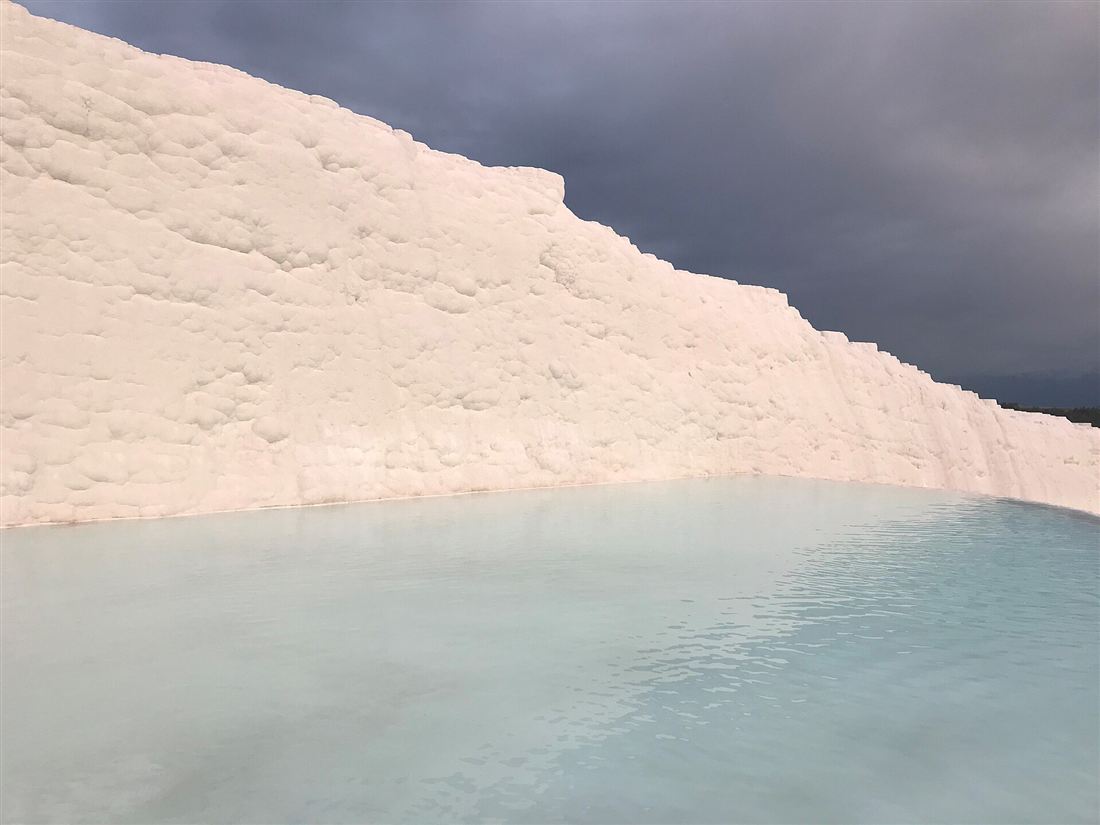 The white travertine wall and turquoise thermal pool of Pamukkale