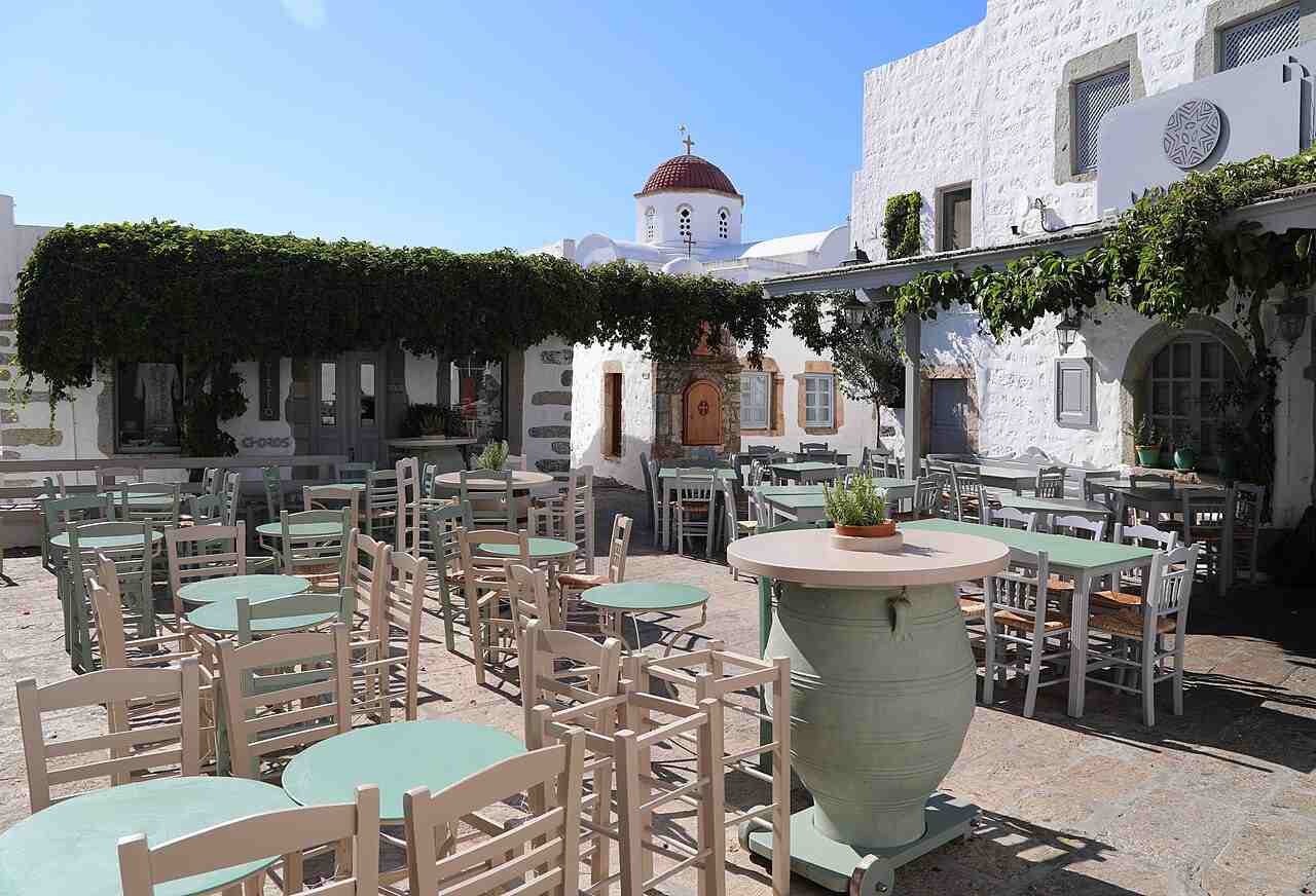 A vine-shaded taverna square in the whitewashed lanes of Chora, Patmos