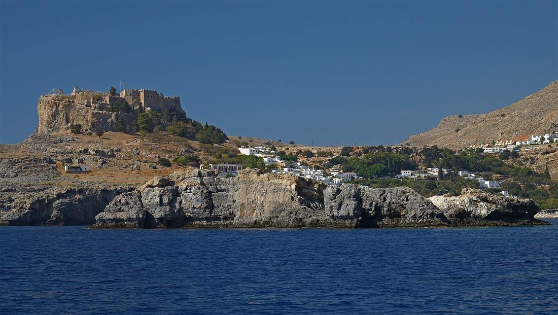 The acropolis of Lindos above the whitewashed village on the coast of Rhodes, reached by airport transfers from Rhodes Airport