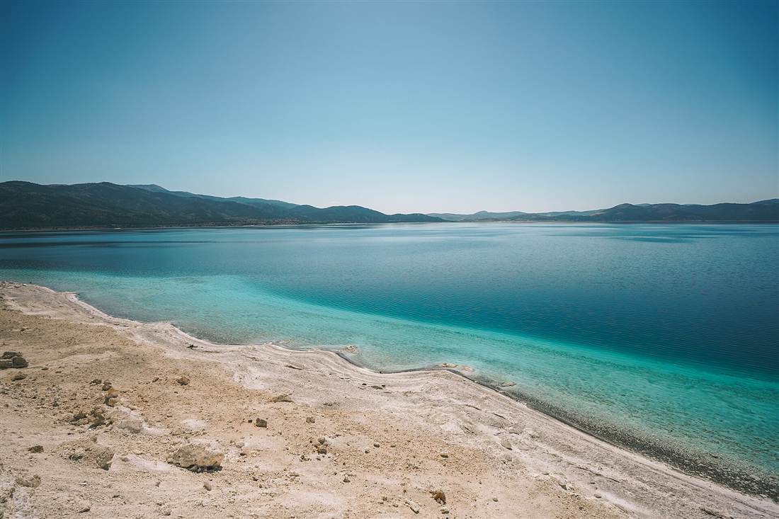 The turquoise water and white shore of Lake Salda on the route to Pamukkale