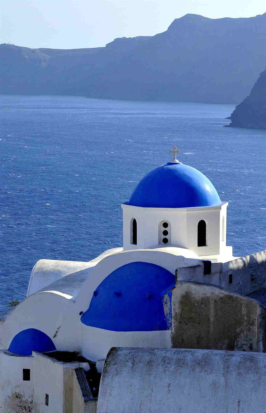 A blue-domed church over the Santorini caldera in Oia, the destination from Chania