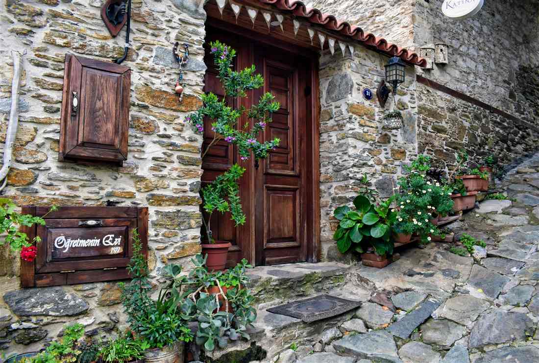 A stone-house doorway on a cobbled lane in Sirince village