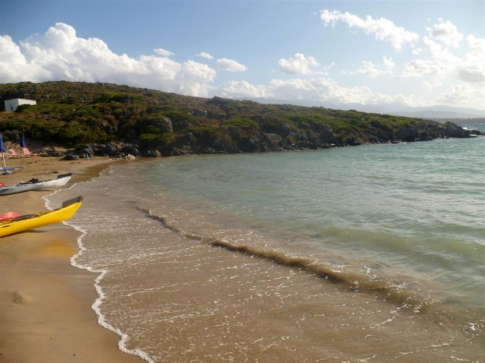 Sea kayaks on the sand at the sheltered Tersanas cove, Akrotiri, Crete