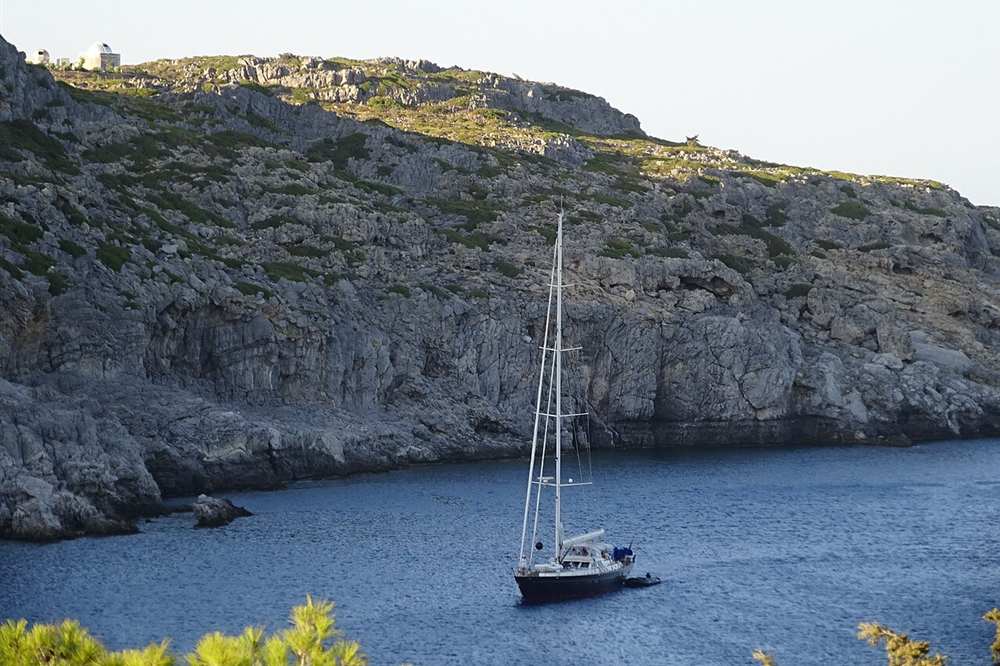 A yacht anchored under the cliffs inside Anthony Quinn bay, Rhodes