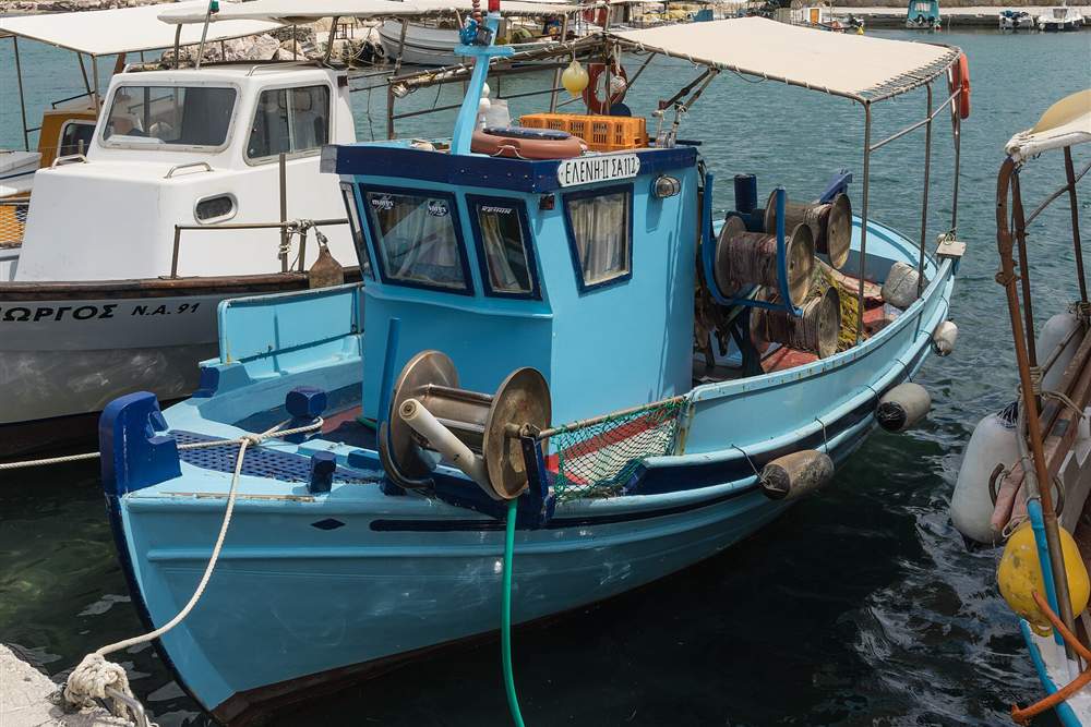 Blue wooden fishing boat with nets in a Greek harbour