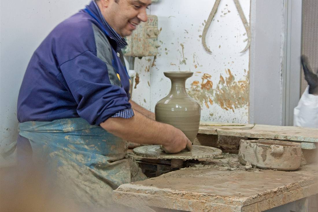 Athens pottery class: a Greek potter shaping a clay vase on the wheel