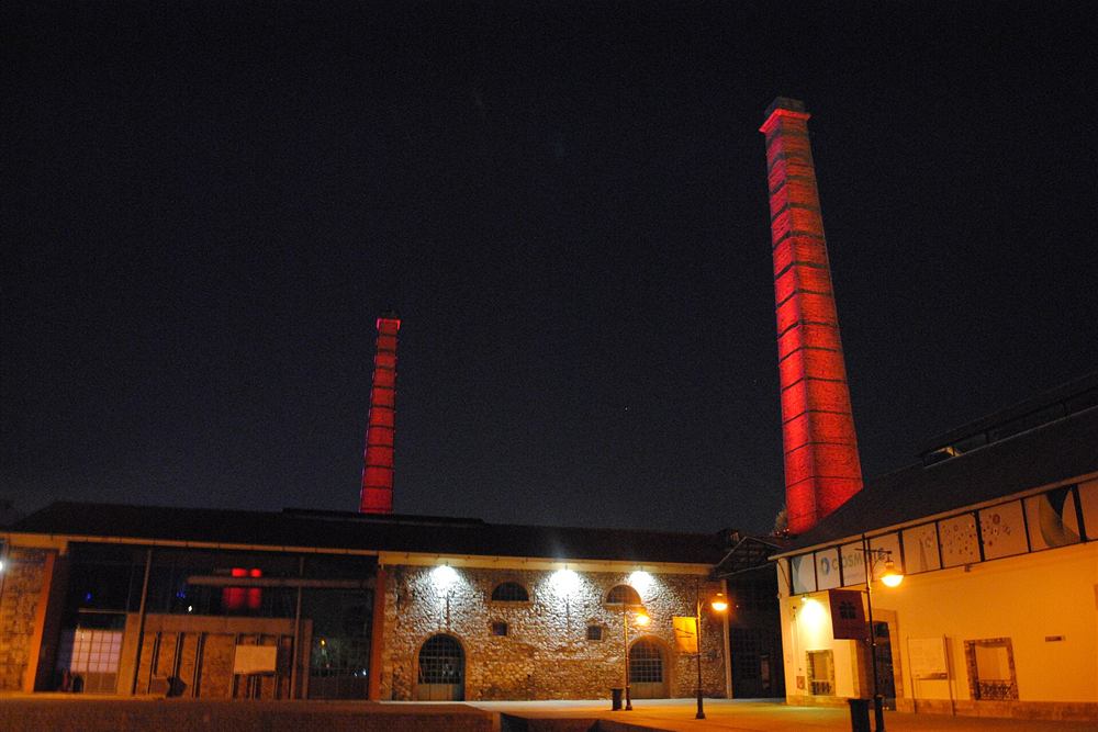 The red-lit chimneys of the Technopolis old gasworks in Gazi, Athens, at night