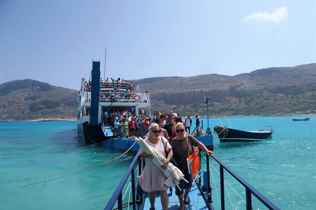 Balos boat trip passengers leaving the ferry by the floating platform in Balos lagoon