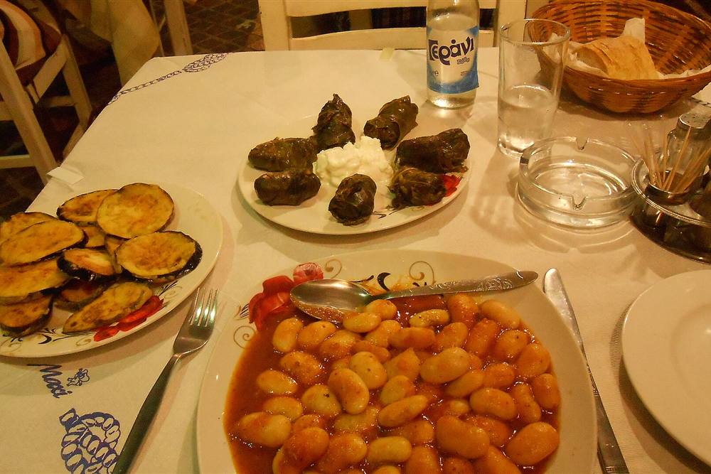Chania food tour meze of dolmades, gigantes beans and fried courgette at a taverna table in the old town