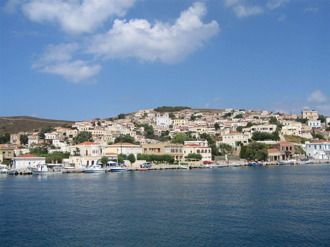 The Oinousses settlement seen from the water with boats along the quay, the marquee sail on a Chios yacht charter
