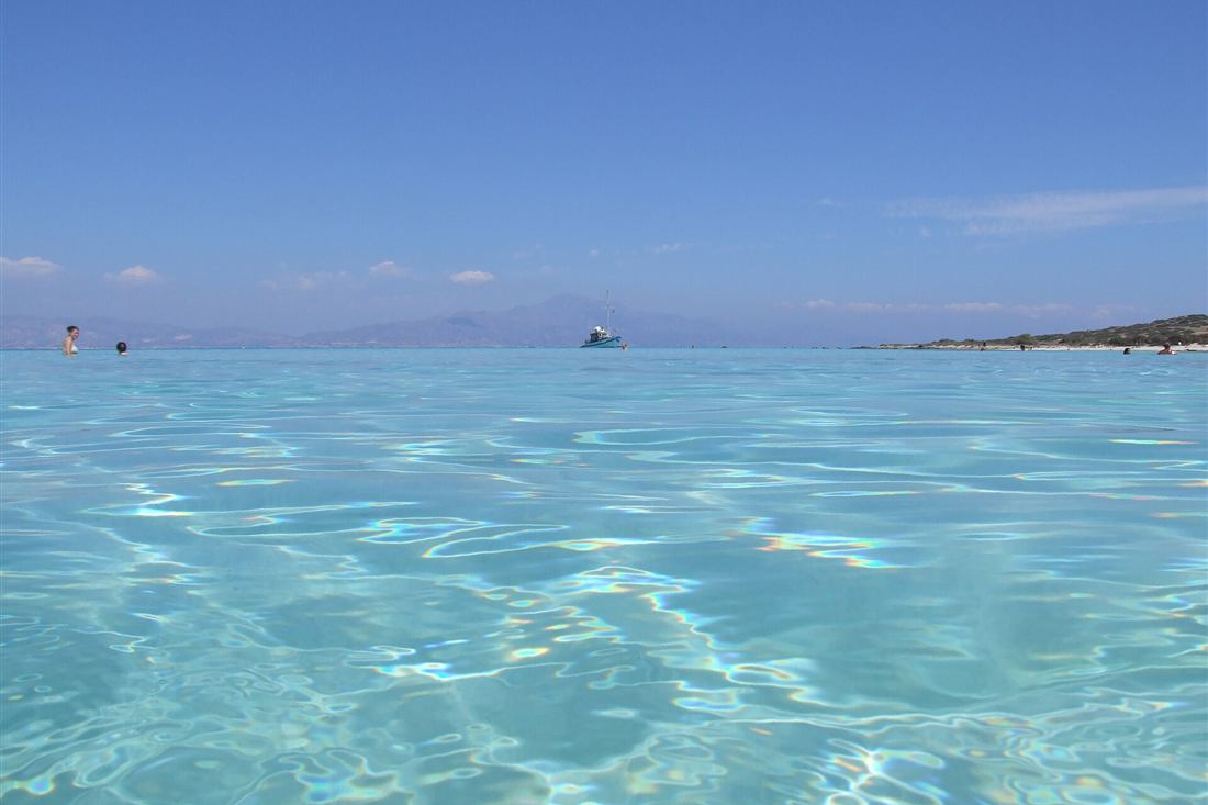 Chrissi island cruise boat anchored off the shallows with Crete behind