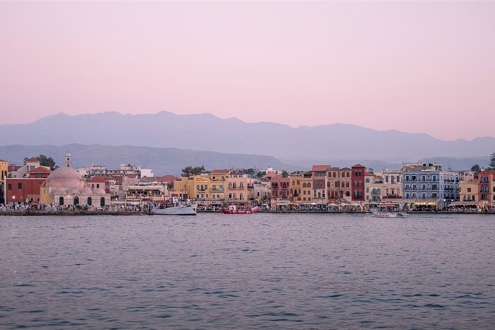 The Venetian harbour of Chania at dusk with the White Mountains behind