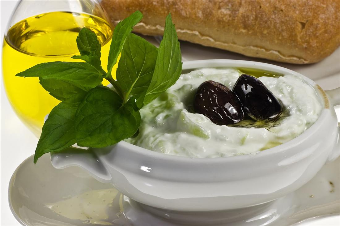 A bowl of tzatziki with olives, fresh mint, olive oil and rustic bread, a staple taught on a Crete cooking class