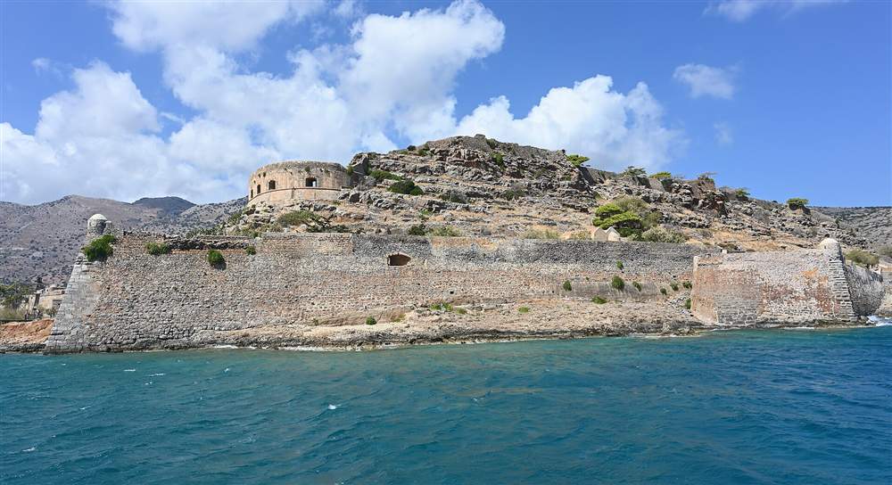 The Venetian sea walls of the Spinalonga fortress rising straight out of the water off the coast of eastern Crete