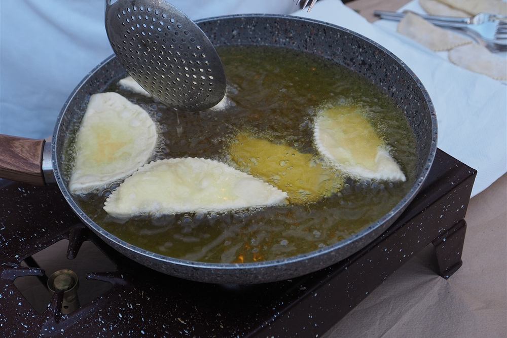 Mizithropites, the Cretan cheese pies, frying in olive oil at a village kitchen
