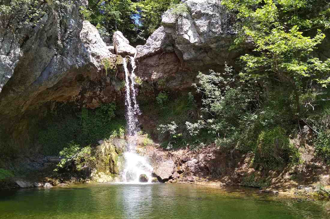 Drymonas waterfall dropping into a green forest pool in north Evia