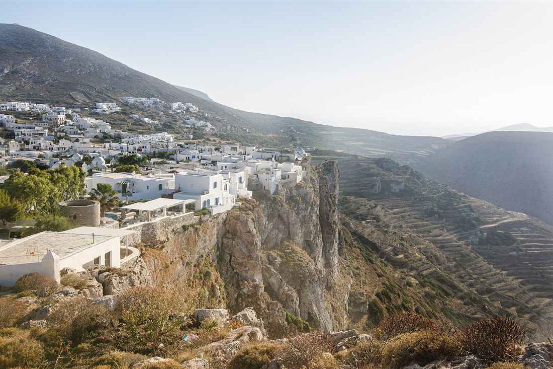 The Chora of Folegandros on its cliff edge above the terraced slopes the vines grow on