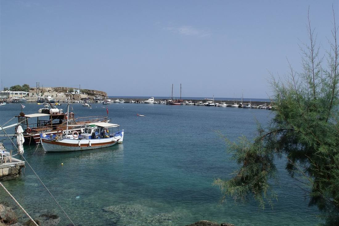 A hire day boat moored in the clear water of the Hersonissos old harbour