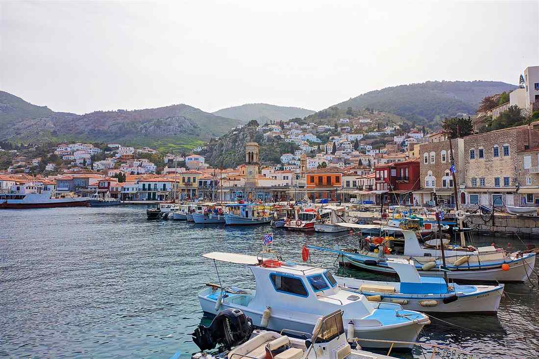 Small motorboats moored in Hydra harbour below the stone town, the start of a Hydra boat rental