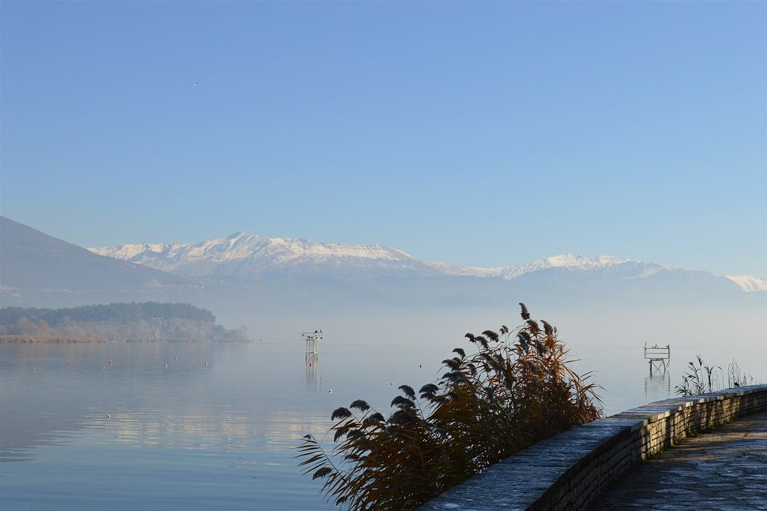 Lake Pamvotida at Ioannina with the snow-capped Pindus behind and the island in the mist, the crossing on Ioannina tours