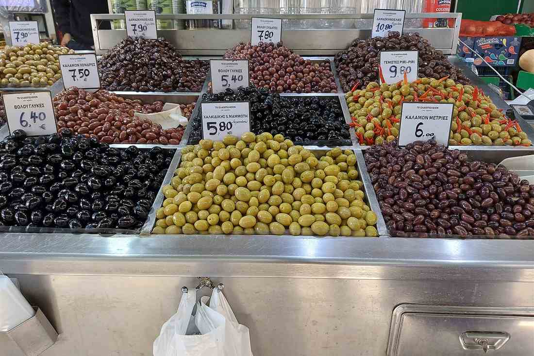 Kalamata food tour tasting stop with Greek olive varieties laid out at a market stall