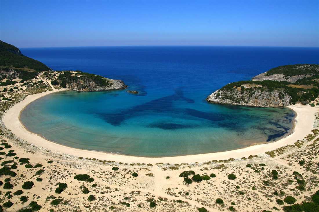 The turquoise omega-shaped lagoon of Voidokilia beach on the Messenia coast reached on a Kalamata yacht charter