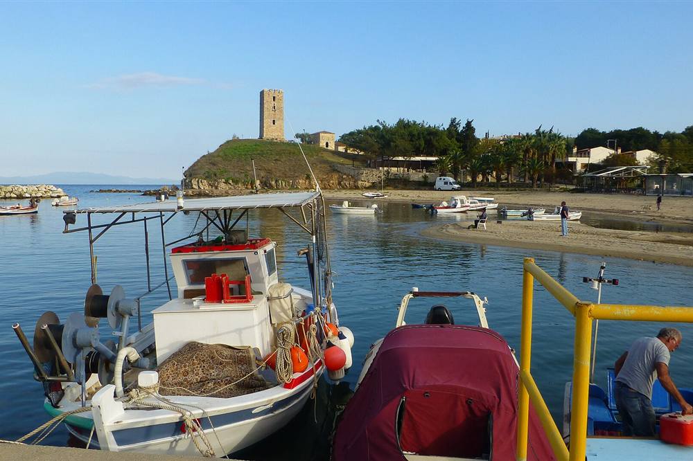 The harbour at Nea Fokea with fishing boats and the Byzantine tower on the headland above