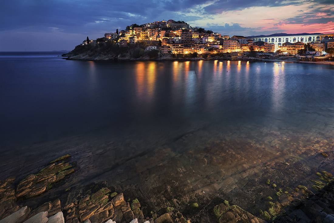 Kavala tuk tuk tour: the Panagia old town and castle lit at blue hour above the harbour of Kavala