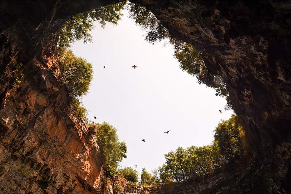 The open roof of Melissani cave seen from the lake below, Kefalonia
