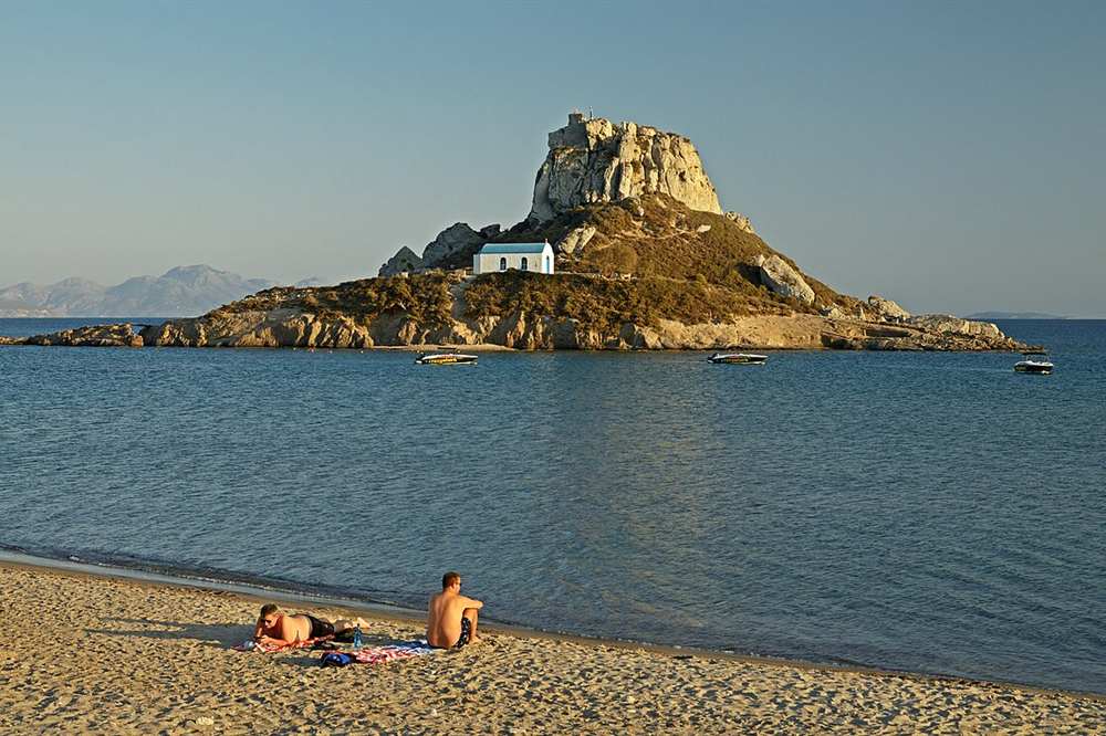 Kastri island and small speedboats off Agios Stefanos beach near Kefalos on Kos