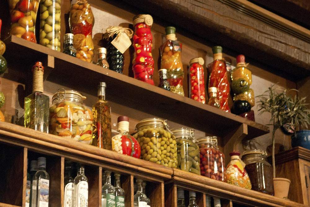 Shelves of preserved olives, peppers and local products at a Kos taverna