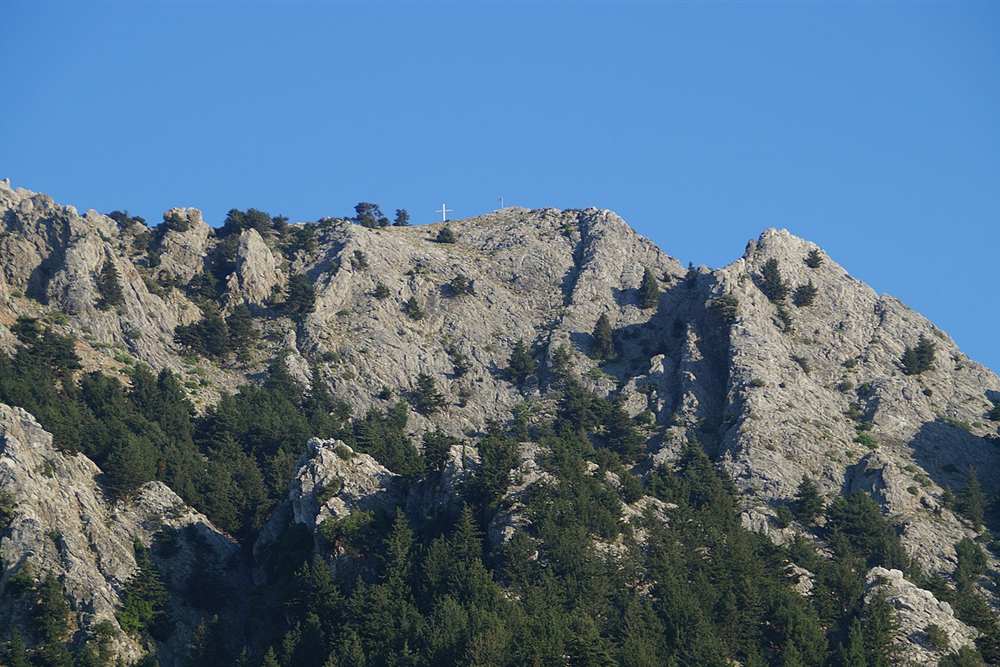 The summit cross on Mount Dikeos above the tracks the jeep safari climbs