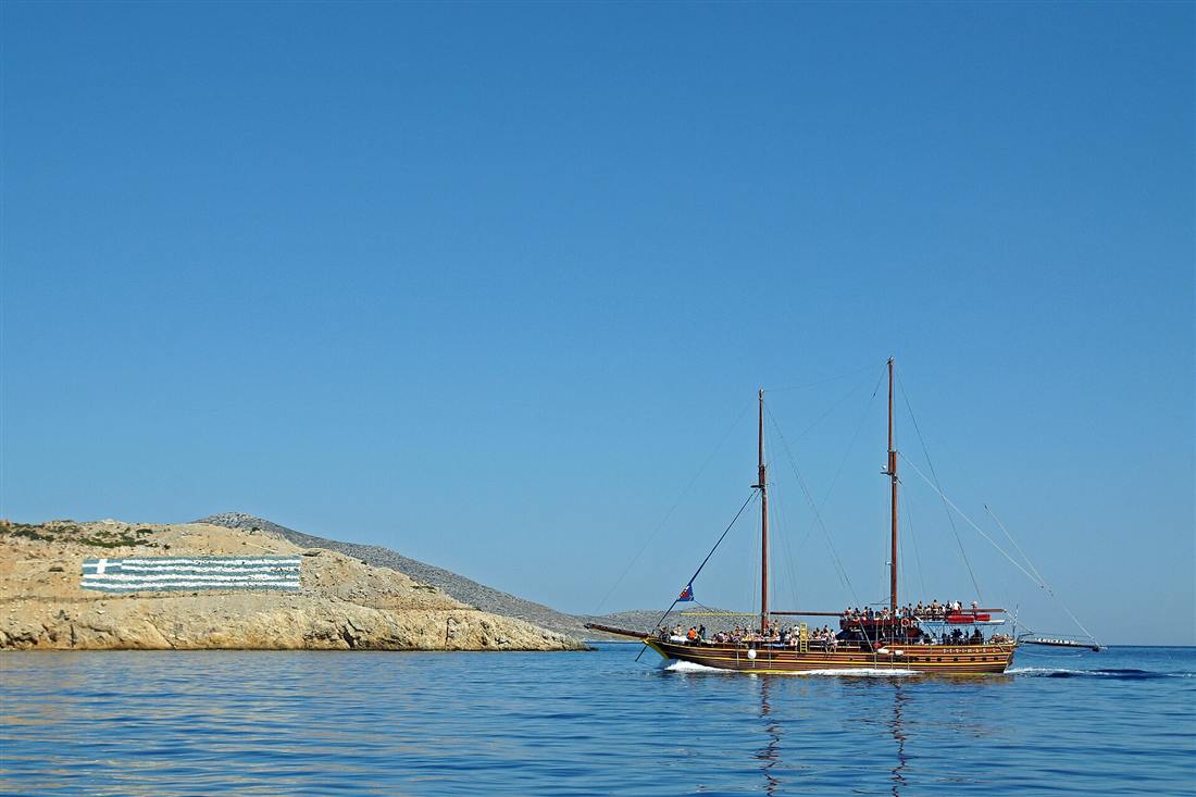 A wooden day boat crossing the deep blue water off the Pserimos headland, the run the Kos scuba diving boats make each morning