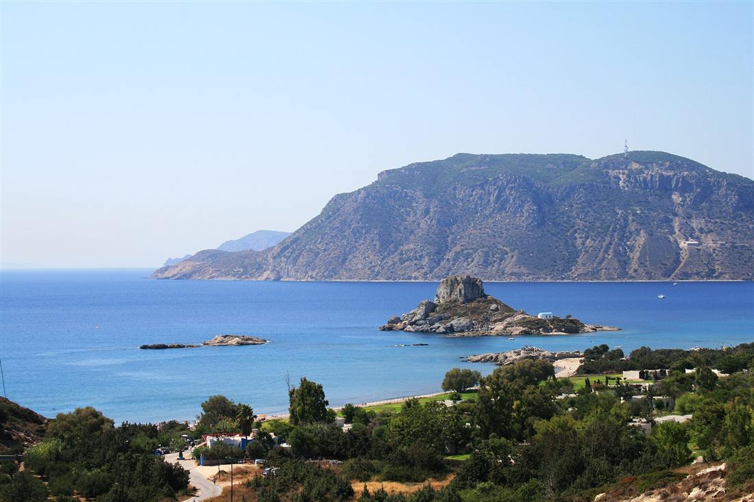The bay of Kefalos on Kos with the rocky islet of Kastri and its white chapel, one of the best shore entries for Kos snorkeling