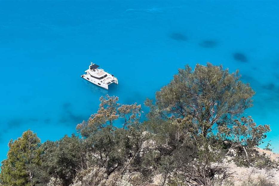 Catamaran anchored in the clear turquoise water off Egremni, Lefkada