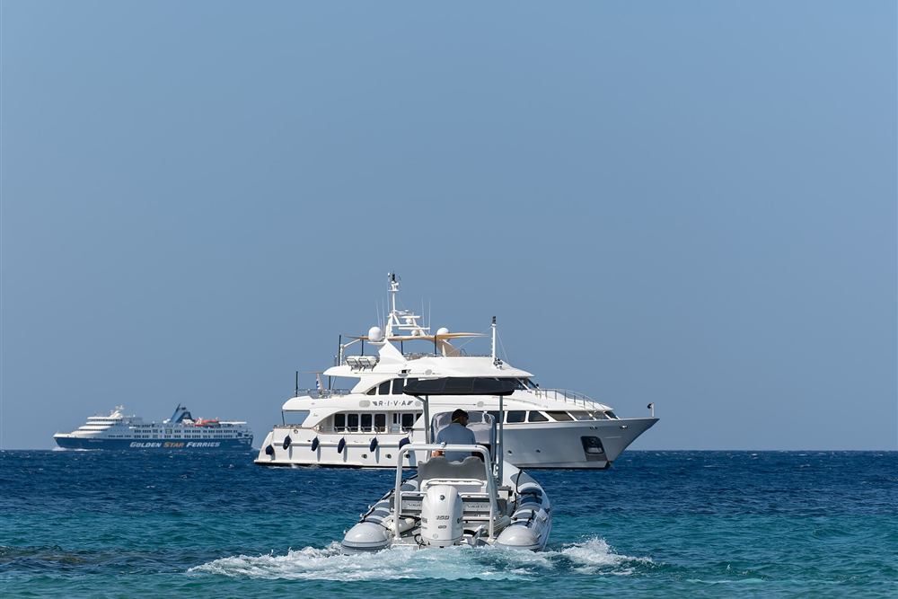 A hire boat running out from the quay on Cycladic water