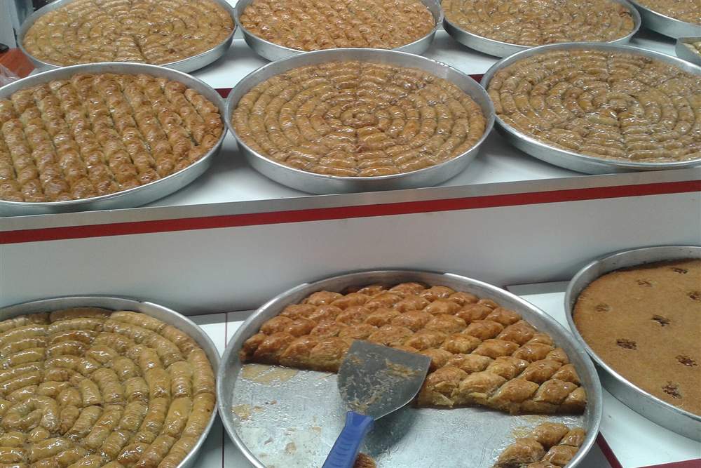 Trays of freshly cut baklava on a bakery counter, the sweet stop at the end of the walk