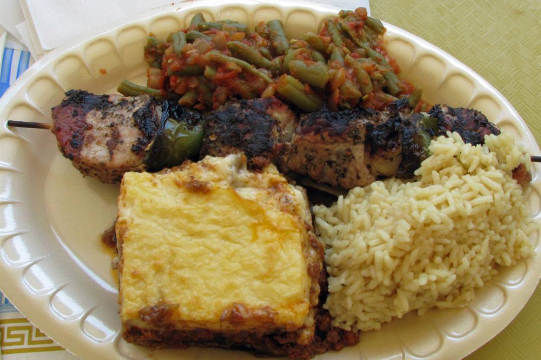 A plate of souvlaki, baked pasta, rice and stewed green beans served at a taverna, the sit-down course on a Naxos food tour