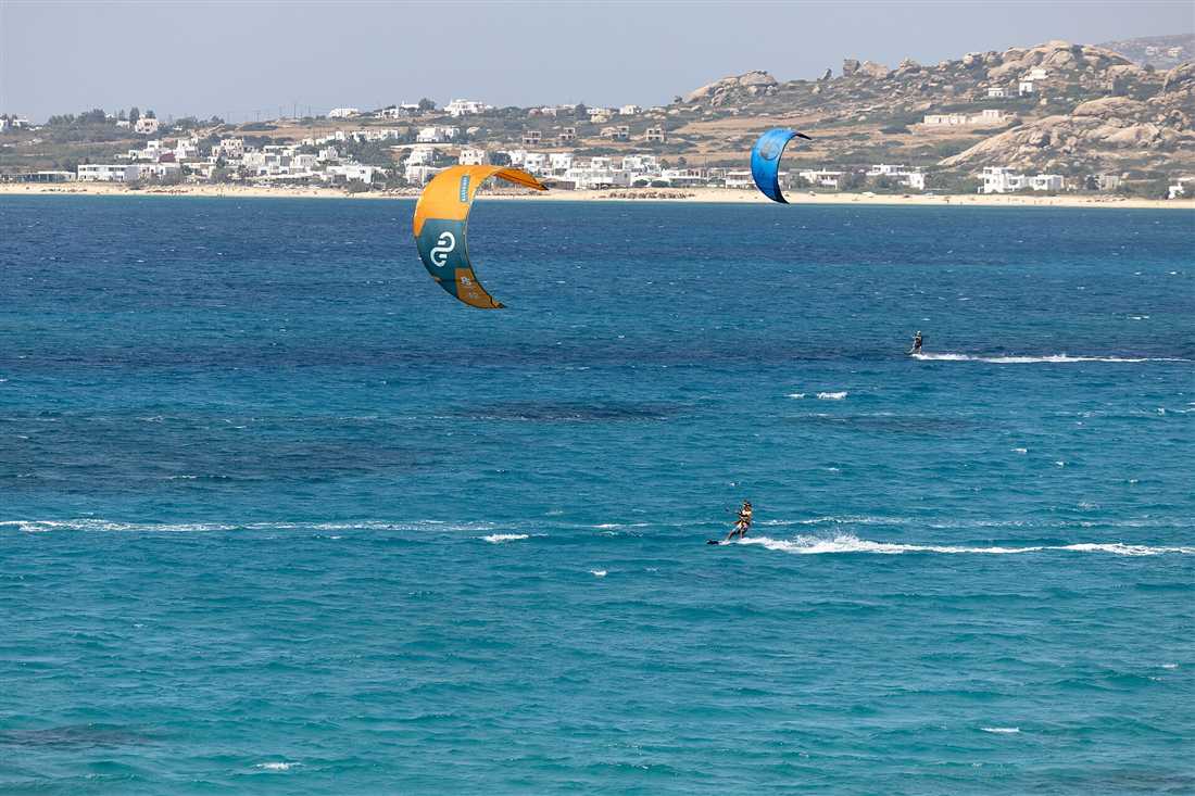 Kitesurfers riding the turquoise water at Mikri Vigla on Naxos