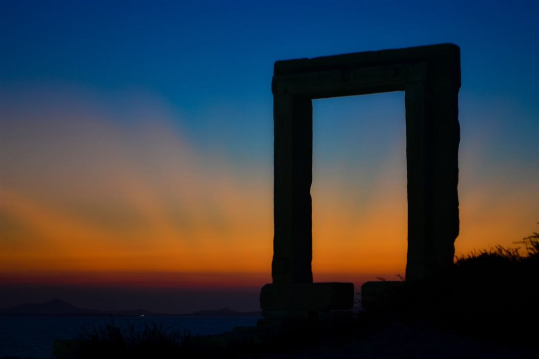 Naxos sunset cruise landmark: the Portara doorway silhouetted against the sunset