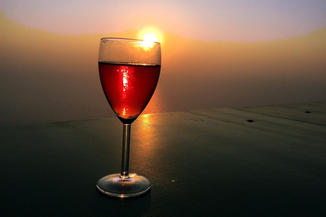 Paros wine tasting: a glass of Cycladic rose wine at sunset over the Aegean