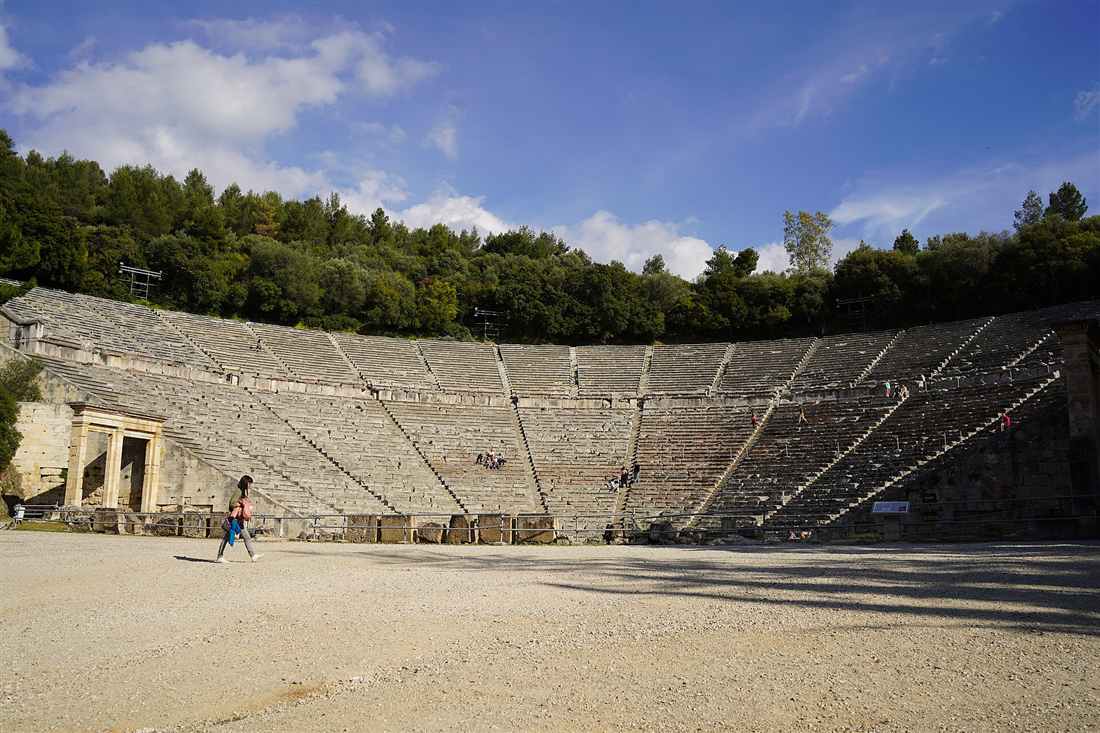 Ancient Theatre of Epidaurus on a Peloponnese tour, stone seats rising under a blue sky