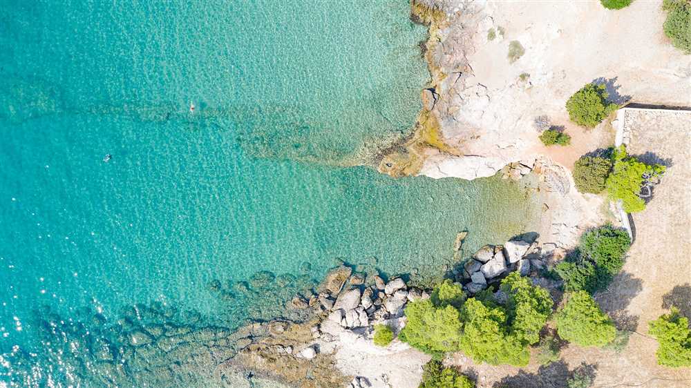 Clear turquoise water over the rocky shore of the Hinitsa cove at Porto Cheli