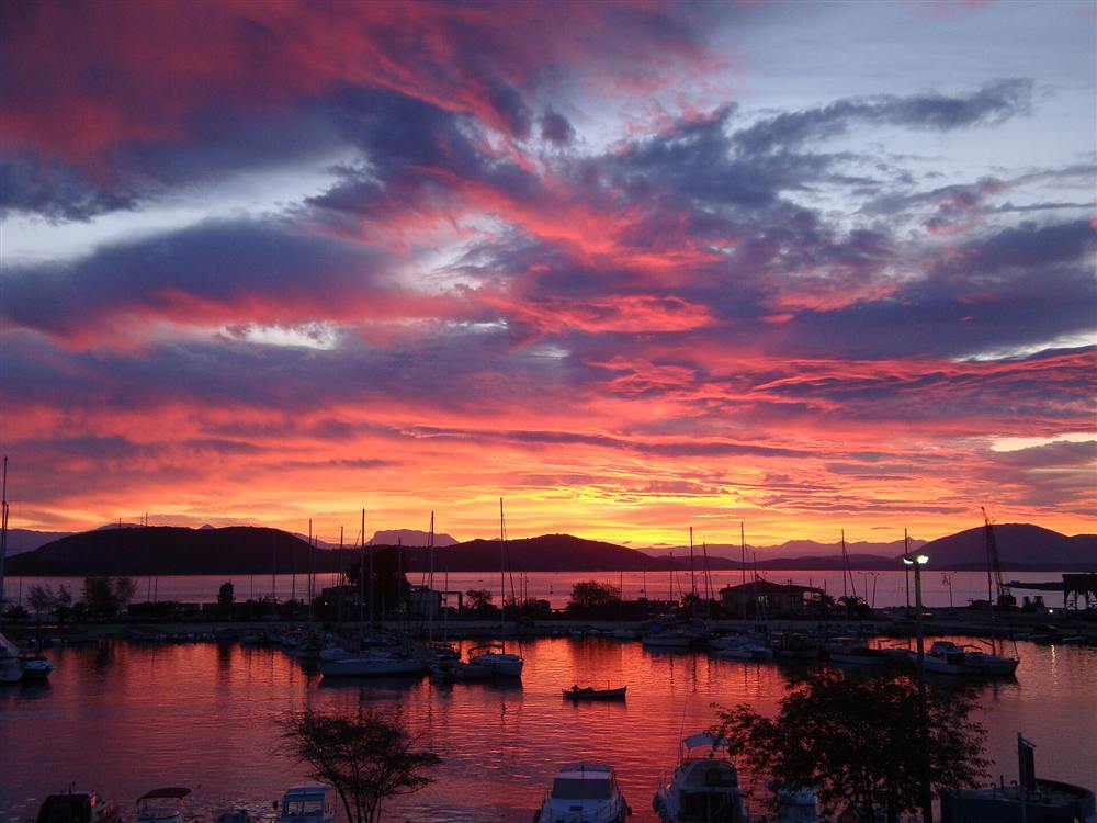 A fiery sunset over the yacht masts of the Preveza marina on the Ionian coast