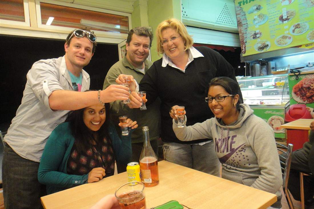 Rethymno food tour guests raising a toast of Cretan raki at a taverna table
