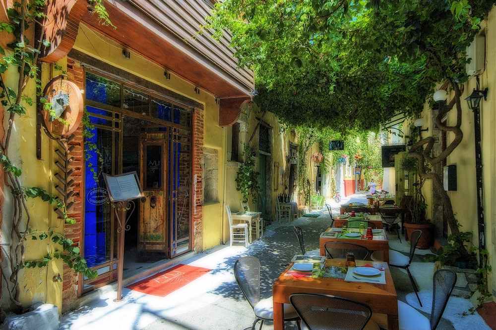 Rethymno food tour stop at a taverna courtyard under vines in the old town lanes