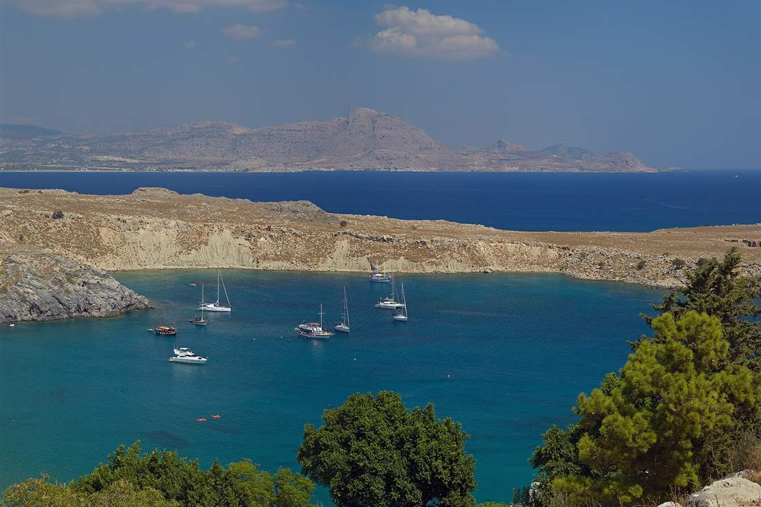 Yachts anchored in St Pauls Bay below Lindos on a Rhodes boat rental