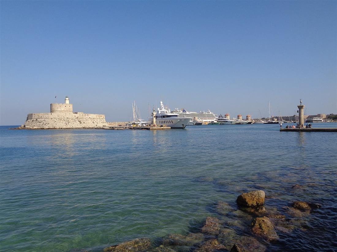 The entrance to Mandraki harbour in Rhodes town with the fort of Saint Nicholas and the windmills, the departure point for Rhodes fishing trips